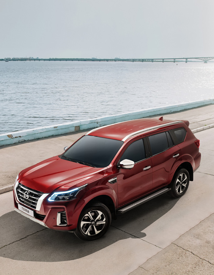 Red Terra on concrete road next to coast line RHD